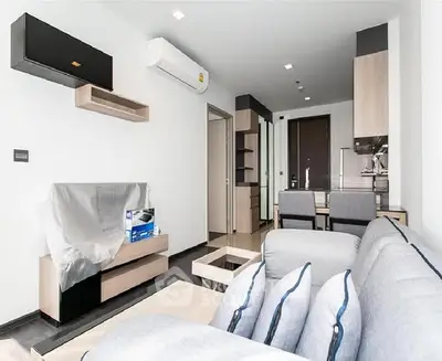 Modern living room with sleek furniture and open kitchen layout in a stylish apartment.