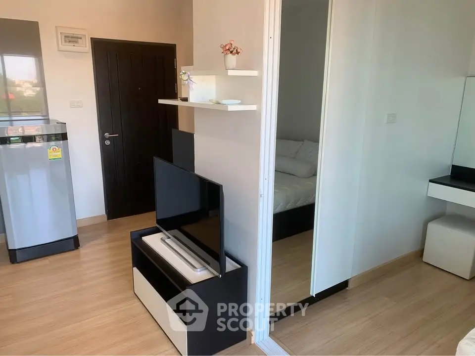 Modern apartment interior with sleek TV stand and mirrored closet in cozy living space.