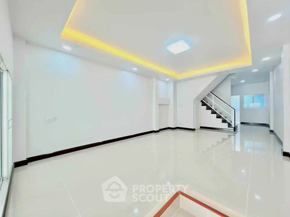 Spacious modern living room with sleek staircase and ambient lighting