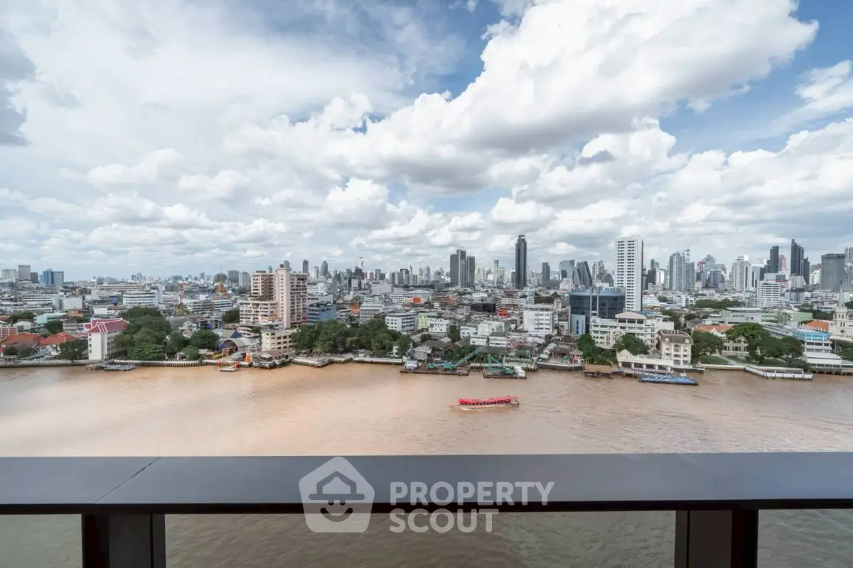 Stunning cityscape view from a high-rise balcony overlooking a river and skyline.