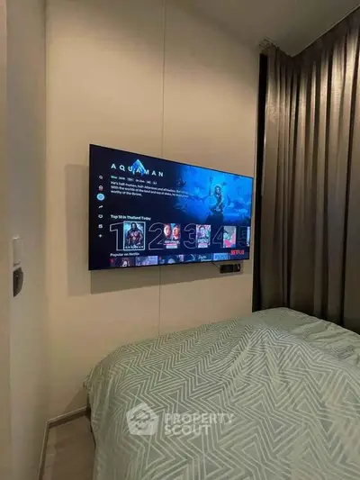Modern bedroom with wall-mounted TV and stylish bedding