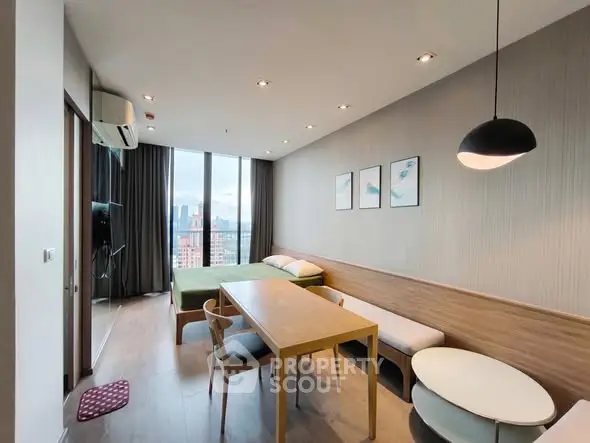 Modern studio apartment with city view, featuring a cozy living area and dining space.