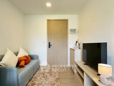 Cozy living room with modern decor and flat-screen TV, perfect for relaxation.