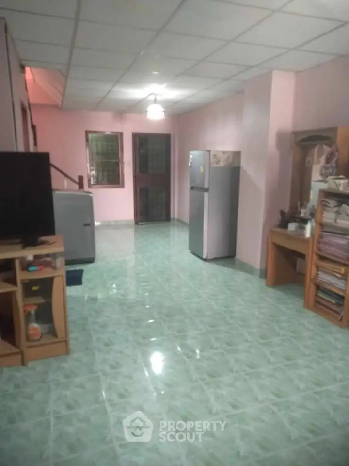 Spacious living area with tiled flooring and modern appliances, perfect for comfortable living.