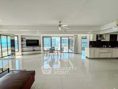 Spacious modern living room with open kitchen and stunning city view.