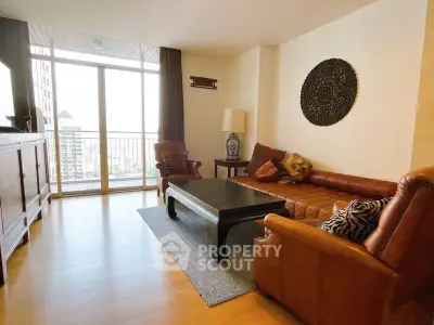 Spacious living room with elegant decor and city view balcony.