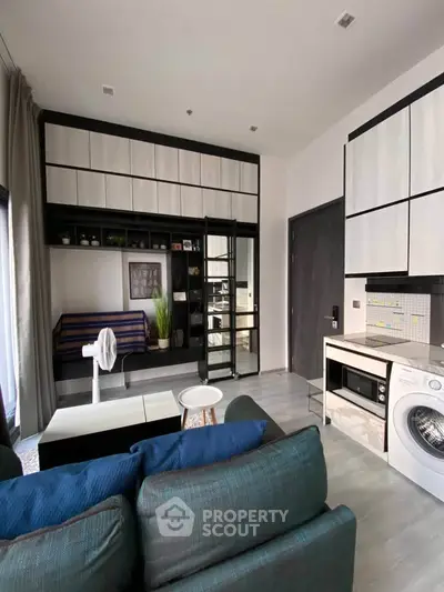 Modern living room with integrated kitchen, featuring sleek cabinetry and built-in appliances for urban living.