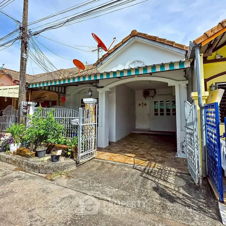 Charming single-story home with gated entrance and satellite dishes, perfect for cozy living.