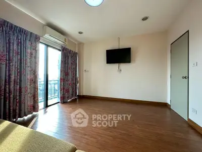 Spacious empty living room with wooden floor and wall-mounted TV