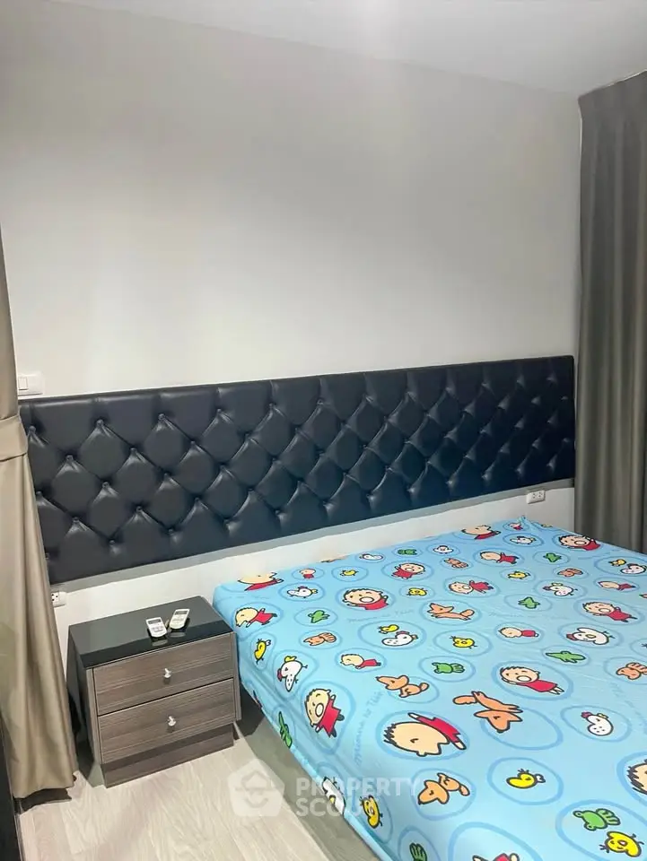 Cozy bedroom with stylish headboard and playful bedding in modern apartment.