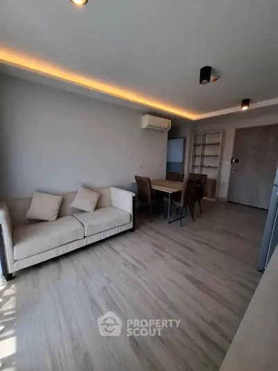 Modern living room with sleek design, featuring a cozy sofa and dining area, perfect for urban living.