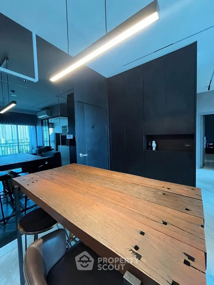 Modern kitchen with rustic wooden table and sleek black cabinetry