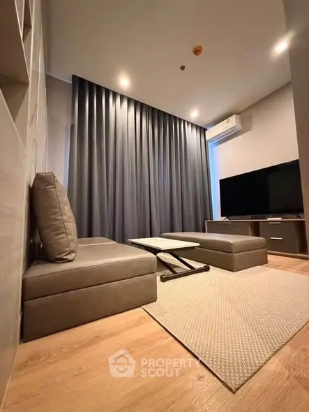 Modern living room with sleek furniture and large TV, perfect for relaxation and entertainment.