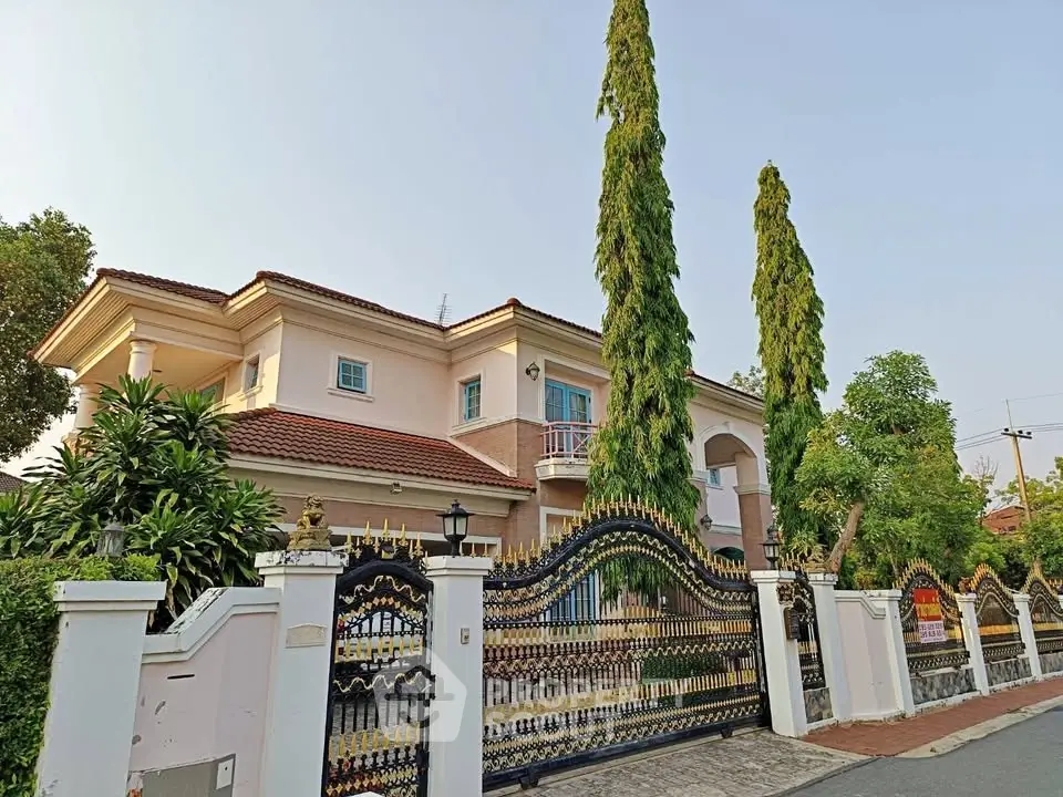 Elegant two-story house with ornate gate and lush greenery
