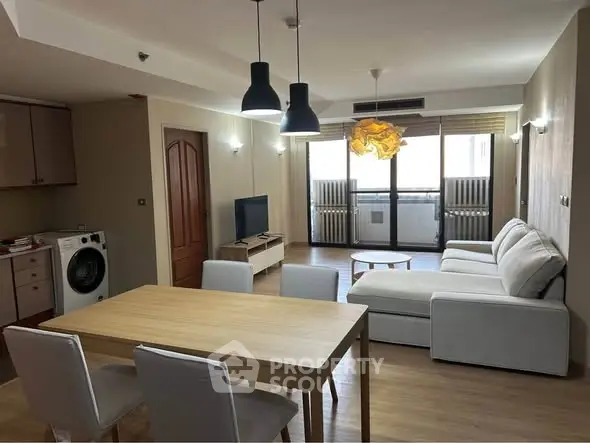 Spacious living room with modern furniture and natural light in a stylish apartment.