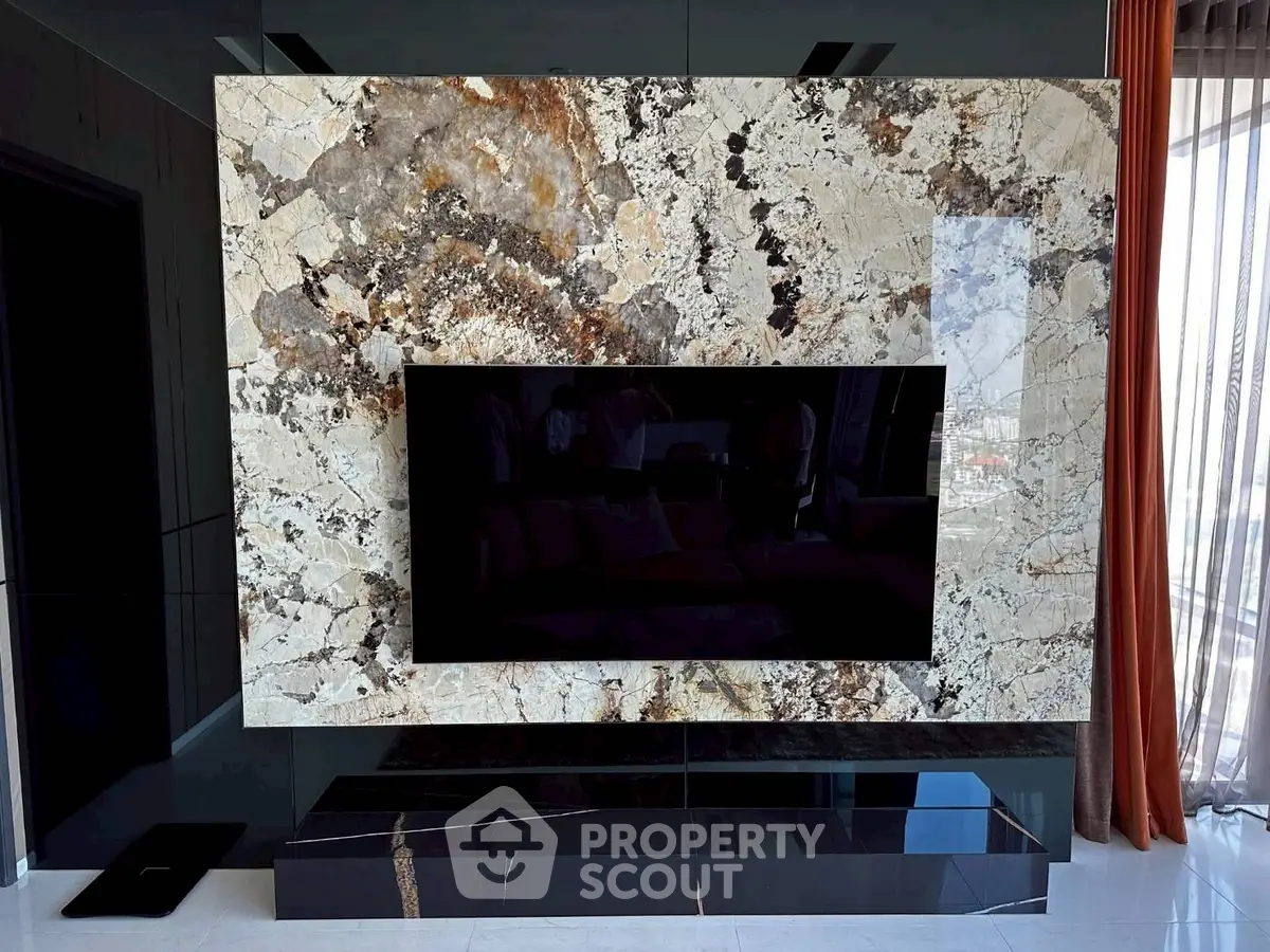 Luxurious living room with a stunning marble feature wall and modern flat-screen TV.
