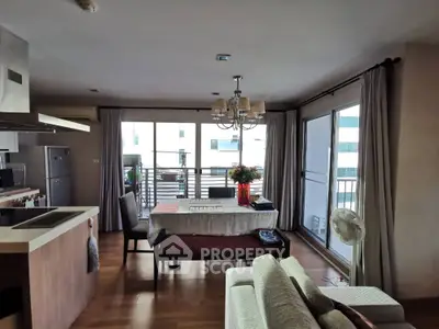 Spacious open-plan living room with modern kitchen and large balcony access