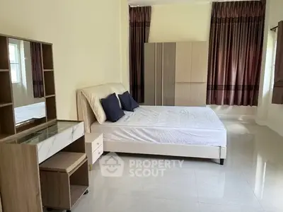 Spacious bedroom with modern furniture and natural light