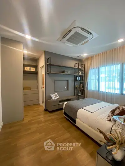 Modern bedroom with stylish decor and natural light, featuring a cozy bed and elegant storage solutions.