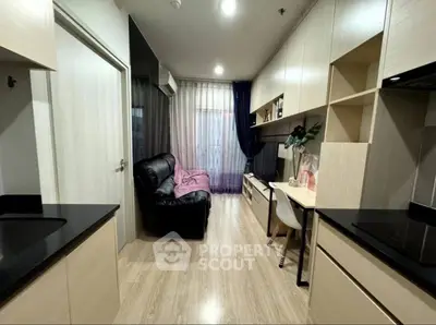 Modern apartment interior with sleek kitchen and cozy living area, featuring stylish furnishings and ample natural light.