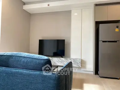 Modern living room with sleek TV setup and stylish blue sofa