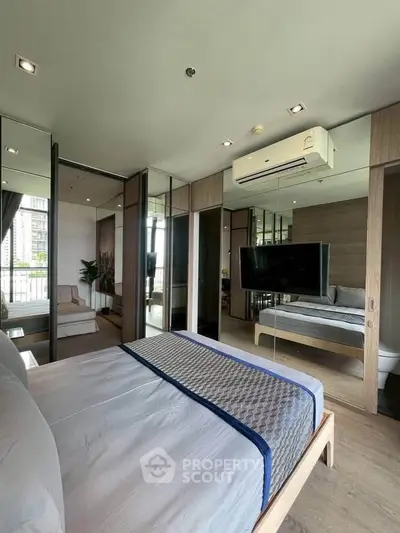 Modern bedroom with mirrored wardrobe and balcony view in luxury apartment