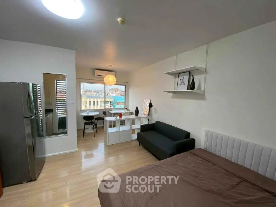 Modern studio apartment with open layout, featuring a cozy living area, dining space, and sleek kitchen appliances.