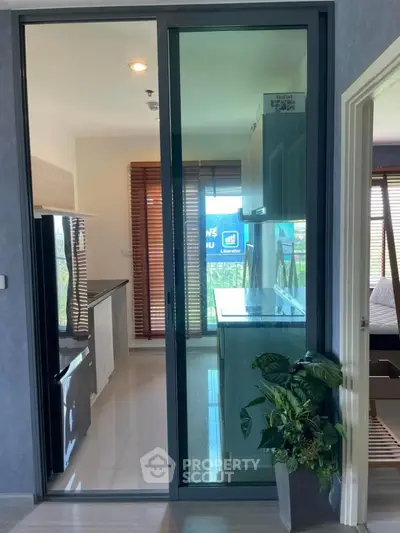 Modern kitchen with sleek design and natural light, featuring a glass sliding door and stylish cabinetry.