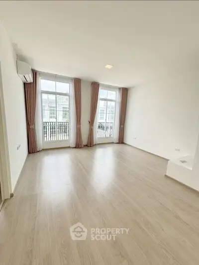 Spacious empty living room with large windows and elegant curtains, perfect for customization.