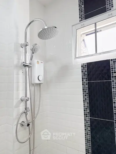Modern bathroom with sleek showerhead and stylish black and white tile design.