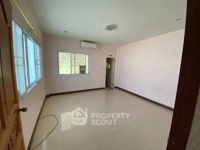 Spacious empty room with large windows and air conditioning, perfect for customization.