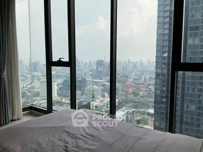 Stunning cityscape view from a high-rise bedroom window, showcasing urban skyline and modern architecture.