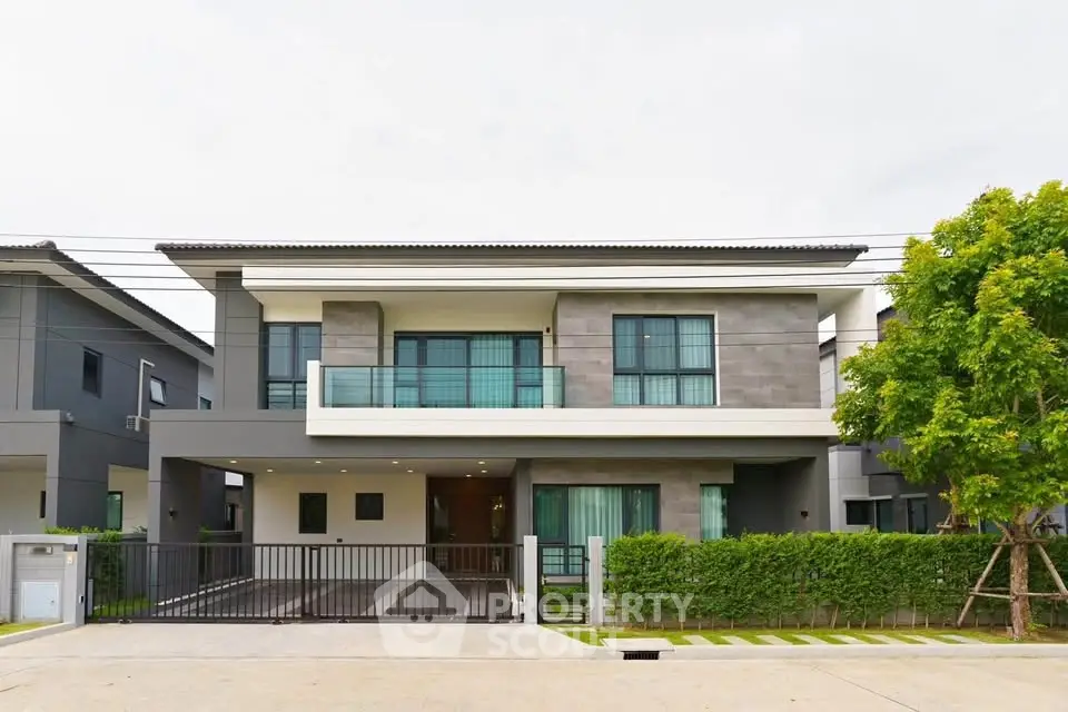 Modern two-story house with sleek design and spacious driveway in a suburban neighborhood.