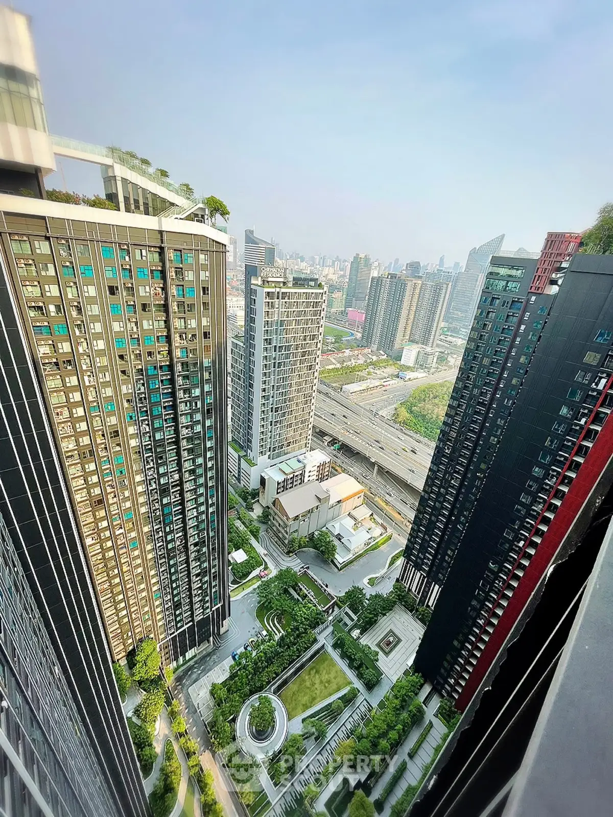 Stunning aerial view of modern high-rise buildings with lush green landscaping in a vibrant urban setting.