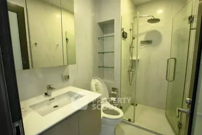 Modern bathroom with glass shower and sleek fixtures in a contemporary apartment.