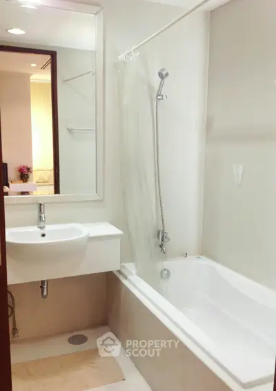 Modern bathroom with sleek white fixtures and bathtub in a stylish apartment.