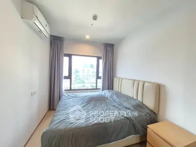 Modern bedroom with large window and city view, featuring a comfortable bed and air conditioning.