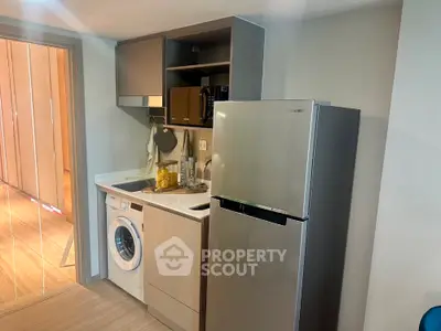 Modern compact kitchen with washing machine and fridge in stylish apartment