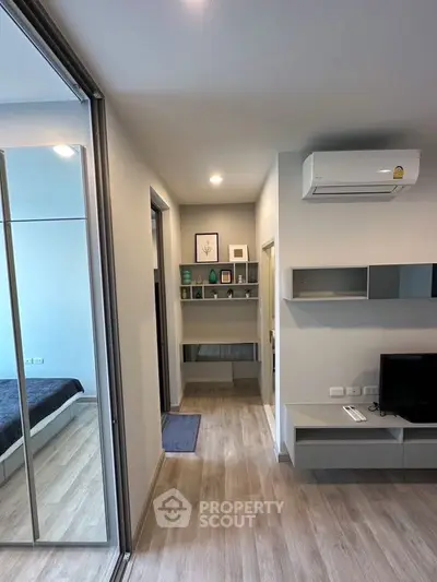 Modern apartment interior with sleek design, featuring a cozy living area and visible bedroom.