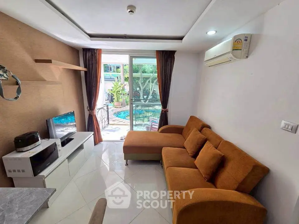 Modern living room with pool view, featuring stylish orange sofa and sleek entertainment unit.