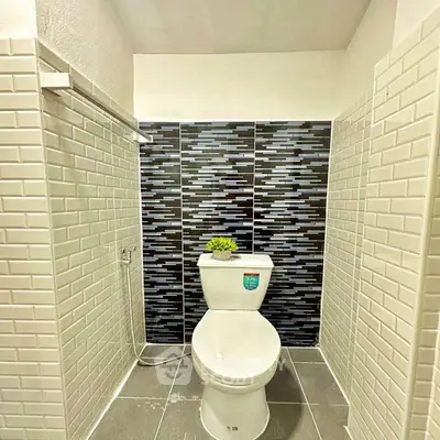 Modern bathroom with stylish tile design and sleek toilet setup.