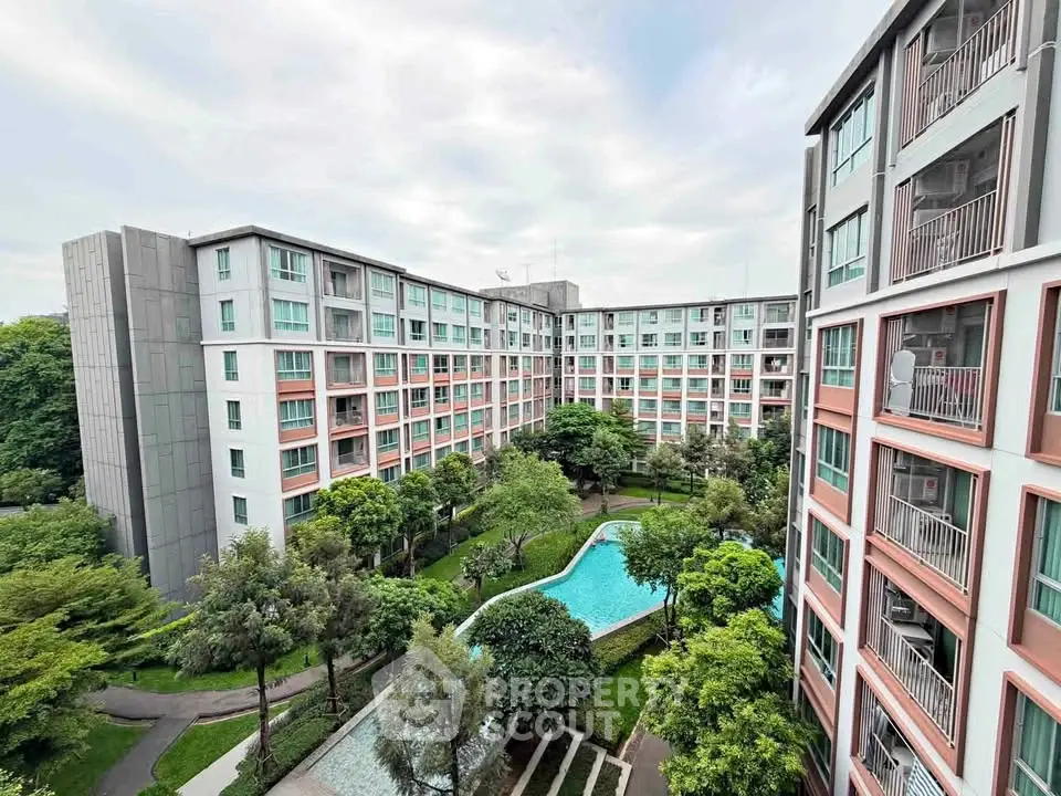 Modern apartment complex with lush gardens and a central swimming pool, offering a serene urban living experience.