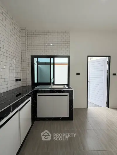 Modern kitchen with sleek black countertops and stylish tile backsplash