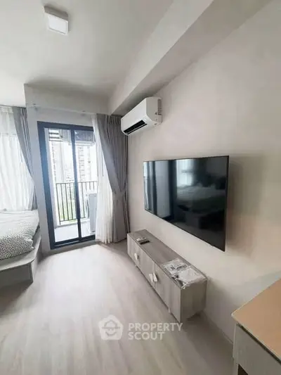 Modern apartment interior with sleek TV setup and balcony view
