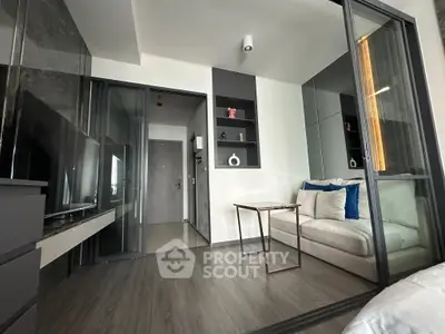 Modern living room with sleek glass partitions and cozy seating area.