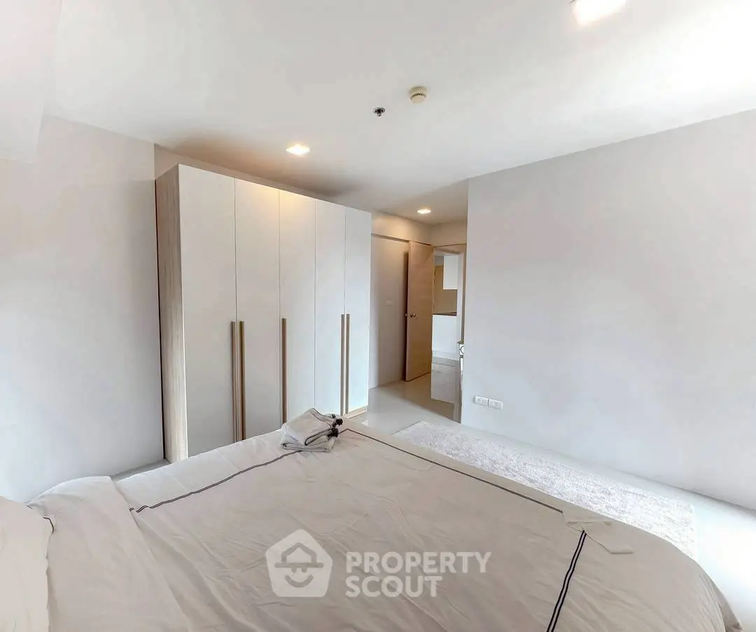Modern minimalist bedroom with sleek wardrobe and cozy bedding