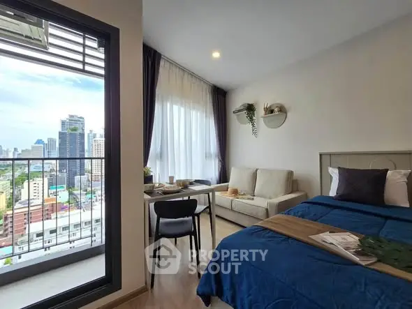 Modern studio apartment with city view, featuring cozy living area and stylish decor.
