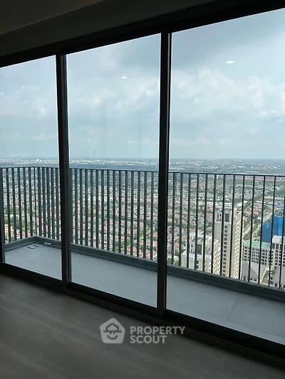 Stunning high-rise apartment with panoramic city view from spacious balcony.