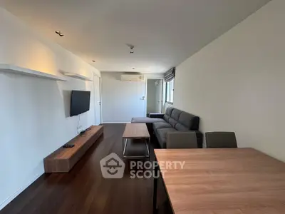 Modern living room with sleek furniture and wall-mounted TV, perfect for urban living.
