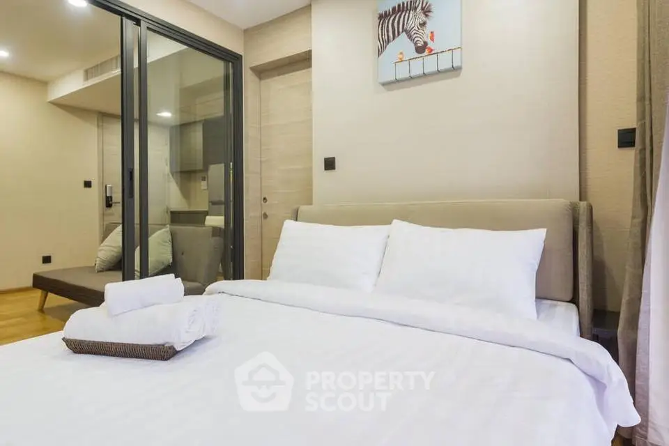 Modern bedroom with cozy bed and glass partition in stylish apartment